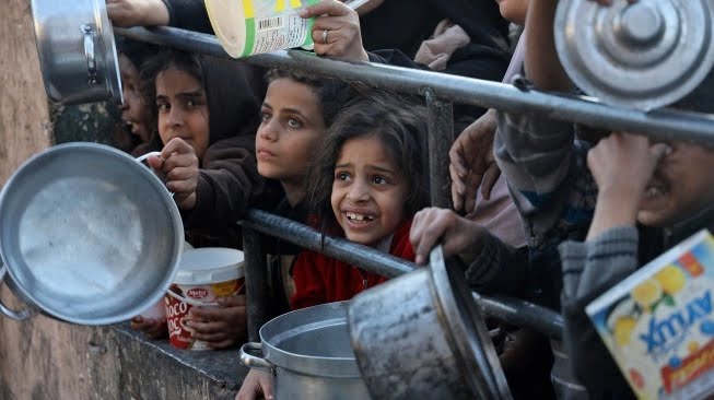 Pengungsi Palestina mengumpulkan makanan yang disumbangkan oleh sebuah badan amal untuk berbuka puasa di Rafah, Jalur Gaza Selatan, Senin (11/3/2024). (Foto : AFP)