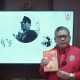 Hasto Kristiyanto berbicara sambil memegang buku biografi Bung Karno. (Arsip PDI Perjuangan via CNN Indonesia)