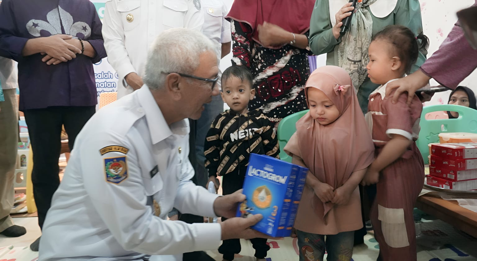 Rudy Salahuddin memberikan bantuan makanan tambahan bagi balita dan ibu hamil pada peresmian Bele Mo’sehati di Kota Gorontalo, Rabu (8/1/2025). (Foto : Diskominfotik)