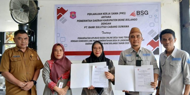 Plt. Kepala Dinas Pemdes Bone Bolango, Nixon Adolong dan Branch Manager PT. Bank SulutGo Kantor Cabang Suwawa, Sri Wahyuni Wantogia memperlihatkan PKS pemanfaatan aplikasi Kasda Online Desa yang terintegrasi dengan Siskeudes link seluruh Pemerintah Desa, Selasa (11/2/2025). (Foto : Dok Istimewa)