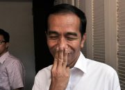 Mantan Presiden, Joko Widodo, sedikit tersenyum menutup mulutnya dengan tiga jari, usai menjawab beberapa pertanyaan wartawan di rumah transisi Jokowi-JK di Jakarta, (9/8/2014). (Foto : Liputan6.com/Johan Tallo)