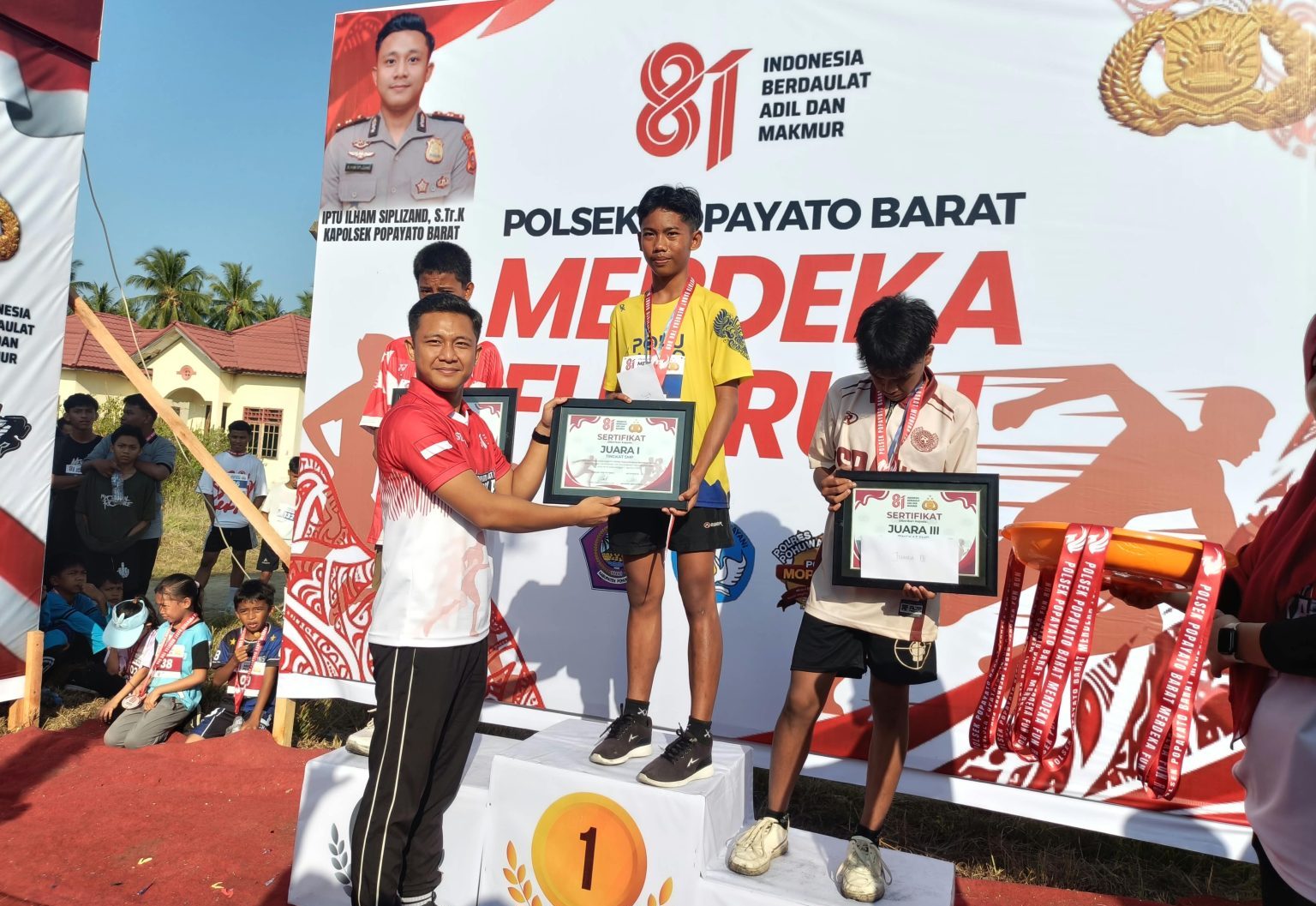 Kapolsek Popayato, IPTU Ilham Siplizand, S.Tr.K Barat saat memberikan piagam kepada peserta FUN RUN.(Foto: Dok. Polri)